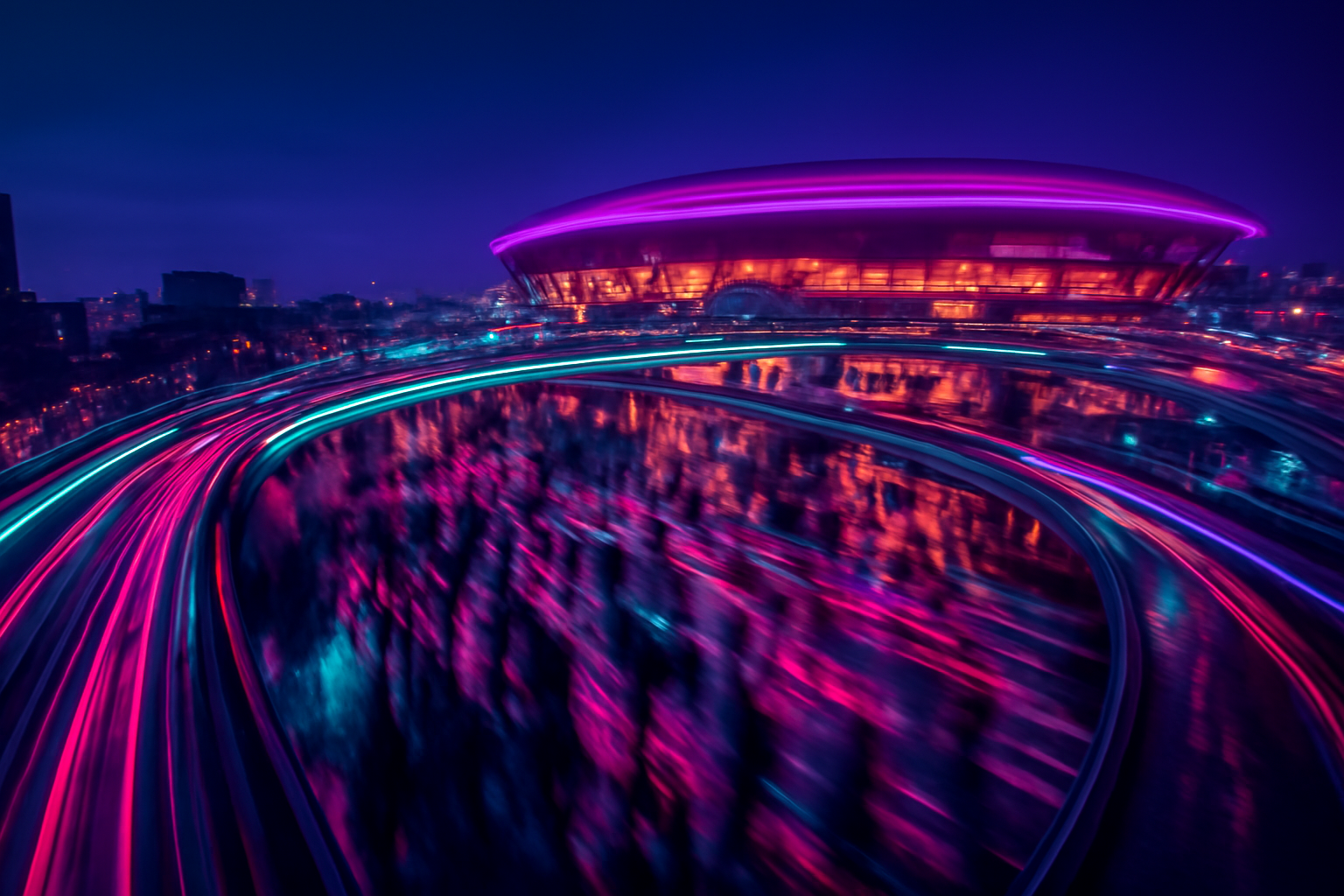 An elevated long-exposure night view of glowing transit paths and pedestrian light trails surrounding a brightly lit urban stadium complex at dusk.